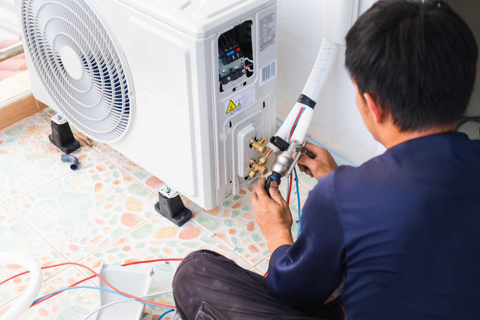 Image of a professional installing an air conditioner.