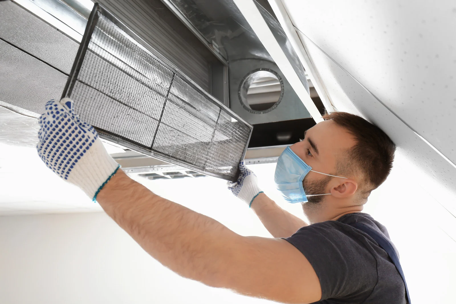 HVAC technician inspecting and replacing an air filter