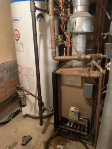 An image of an old installation with a separate water heater and boiler, before upgrading to a combi boiler that combines both into one.