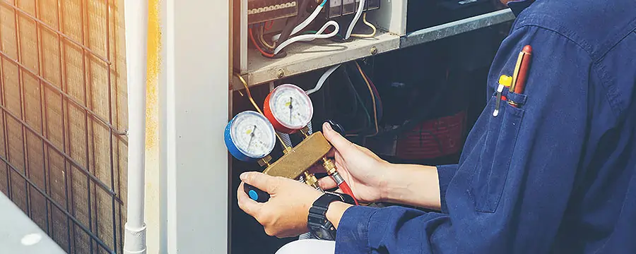 A technician measuring pressure on valves